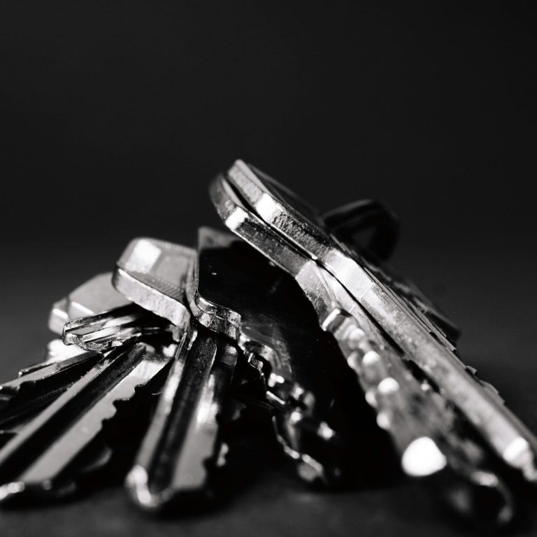 Ansammlung von glänzenden Schlüsseln auf einem dunklen Hintergrund.