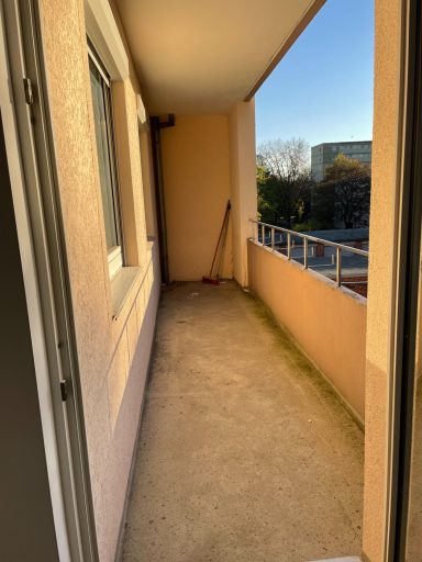 Loggia Blick auf einen leeren Balkon mit glattem Boden und einem Besen in der Ecke.