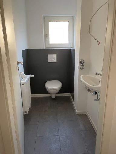 Gäste-WC Kleines Badezimmer mit WC, Waschbecken und einem Fenster.